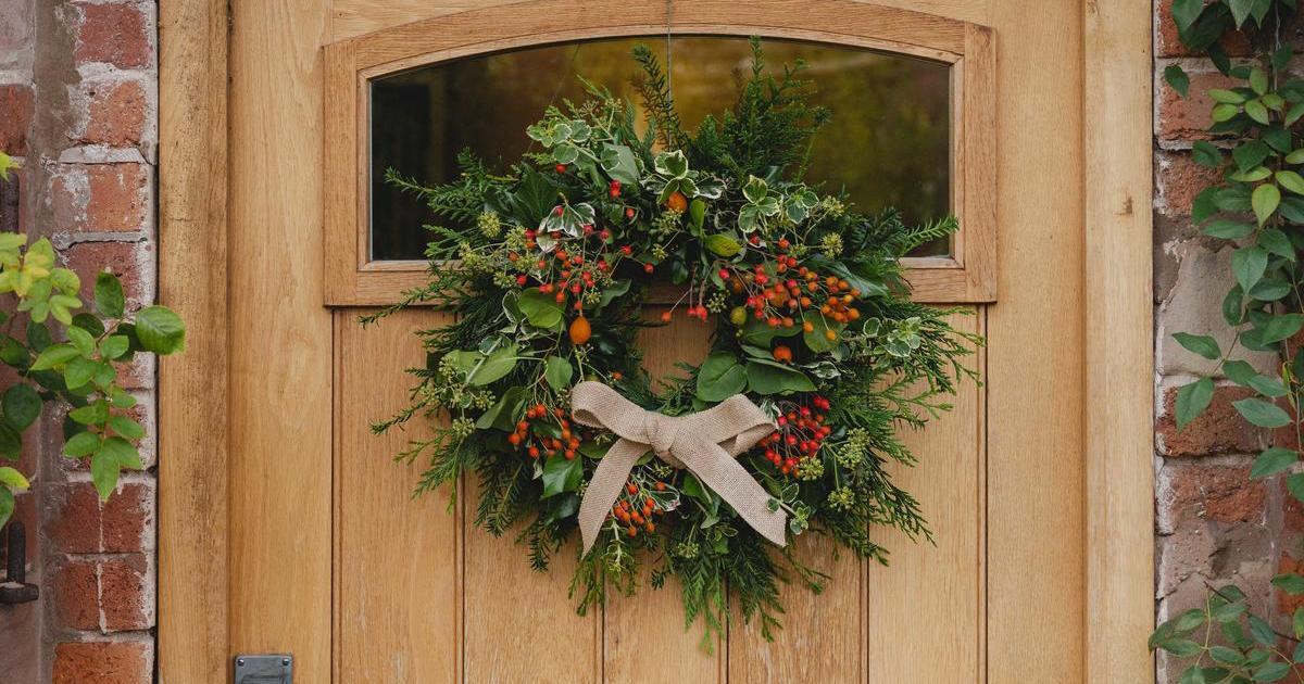 rose hip wreath hung on a wooden door